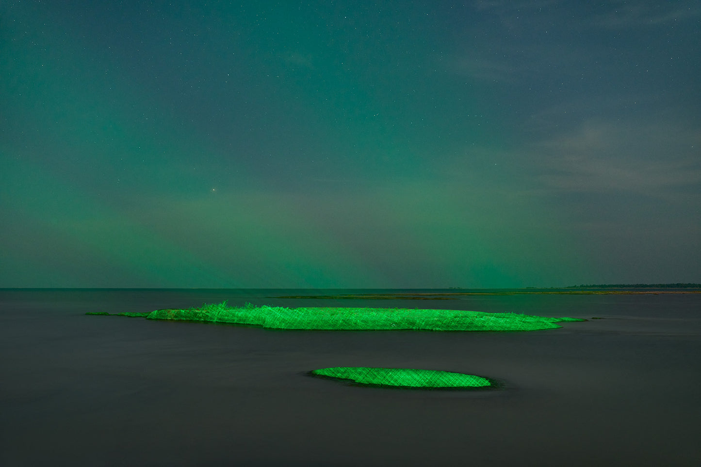Green aurora borealis over a body of water