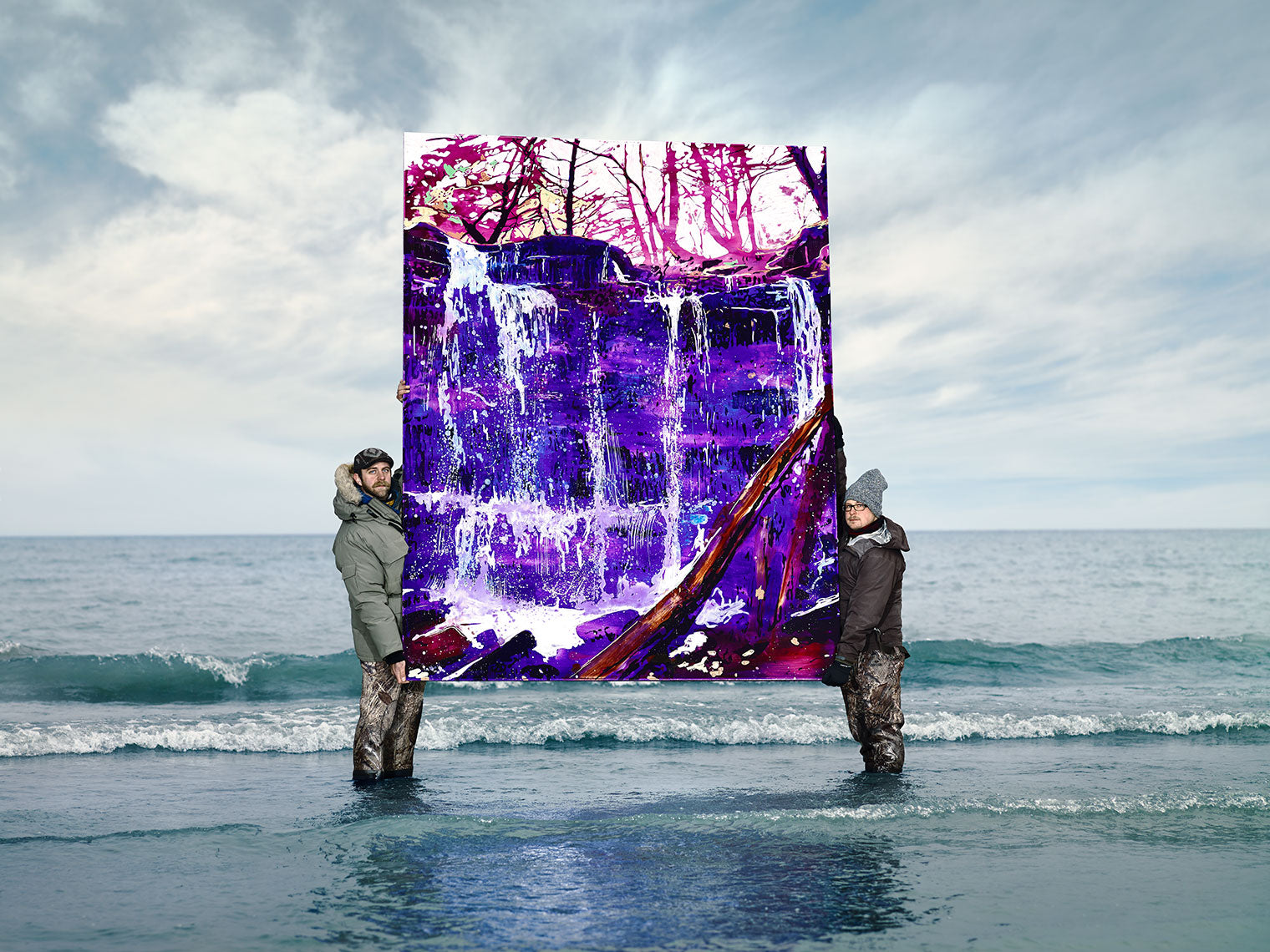Vibrant waterfall painting held in lake shallows by artists.