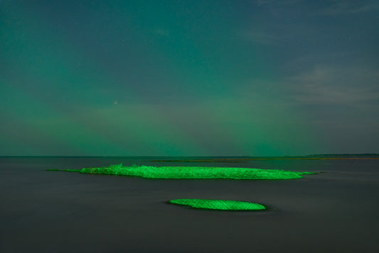 Green aurora borealis over a body of water